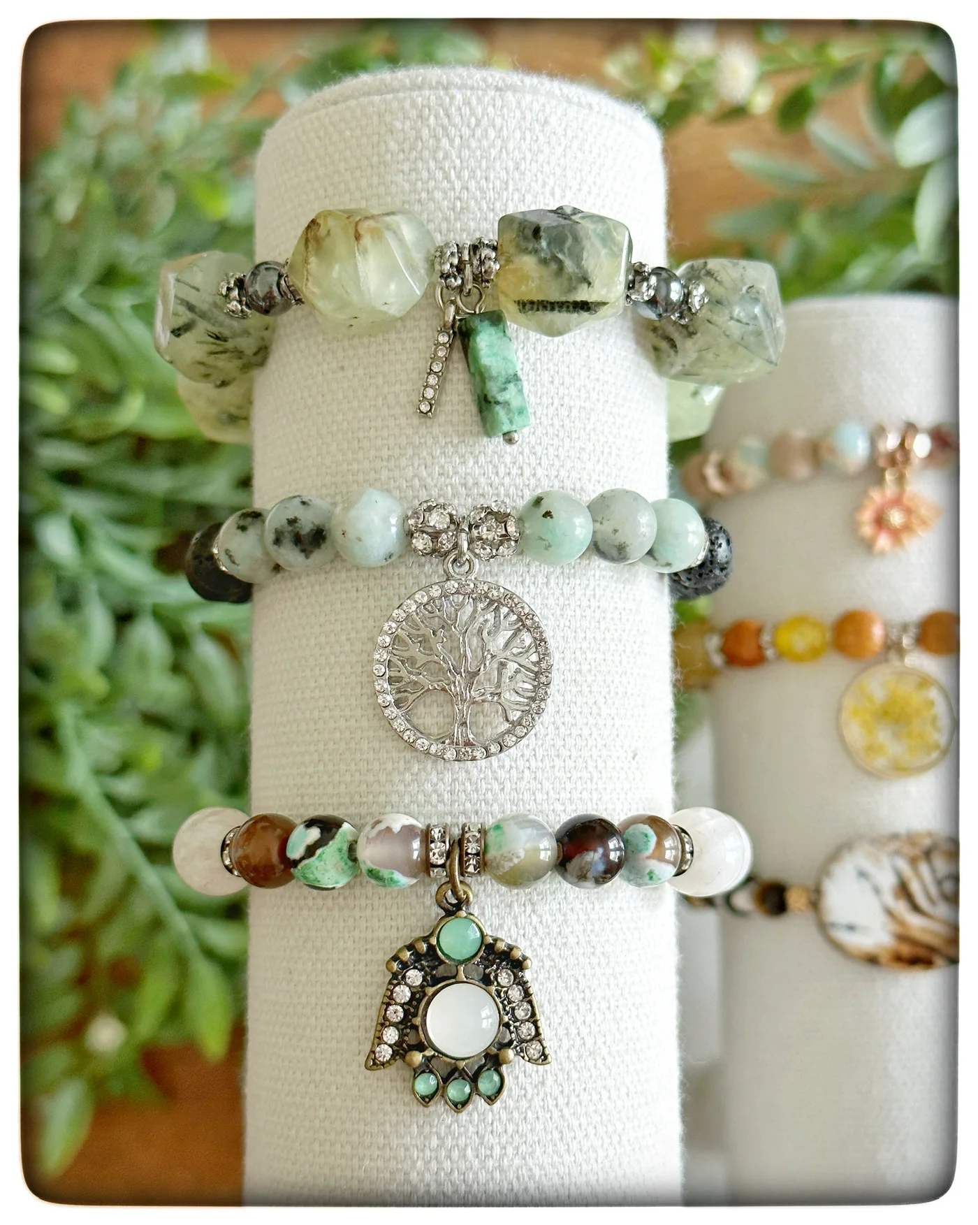 Beaded charm bracelets on a white display stand