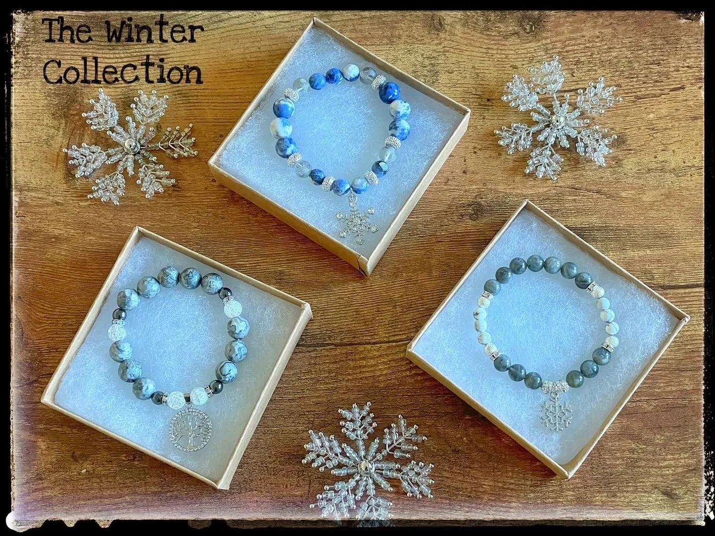 Three pale blue beaded bracelets arranged beside snowflake decorations